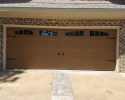 Residential garage door with ornamental hardware and windows