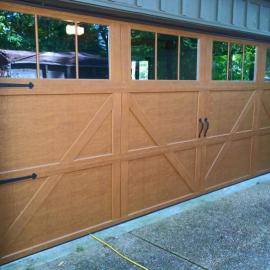Wooden residential garage door with windows